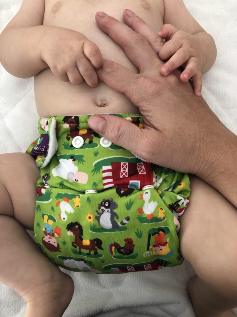 liebevolle-bindung-mama mit säugling in Stoffwindel von Milovia gewickelt und Hand in Hand